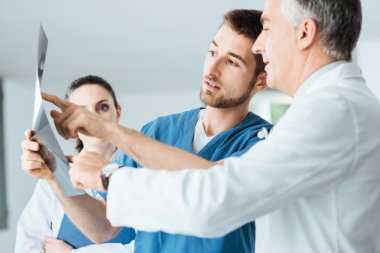 Medical team examining patient's x-ray clipart