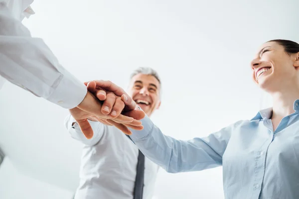 Pessoas de negócios alegres empilhando mãos — Fotografia de Stock
