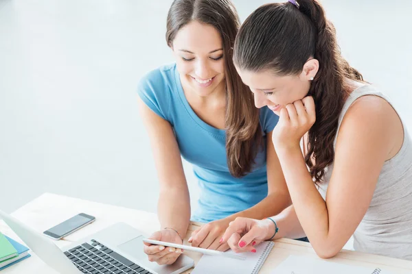 Bonitos estudiantes usando una tableta digital en casa — Foto de Stock