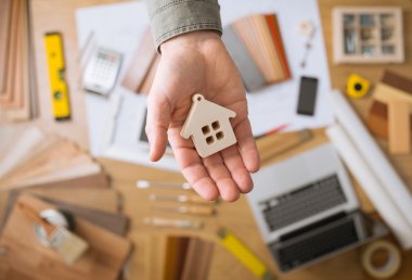 Housing concept, Real estate agent holding a small house