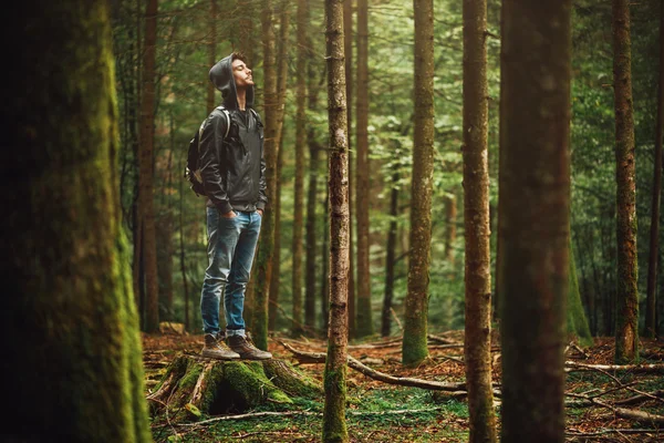 Homme à capuchon posant dans la forêt — Photo