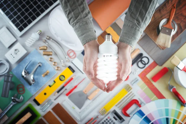 Hombre sosteniendo una lámpara de ahorro de energía CFL — Foto de Stock