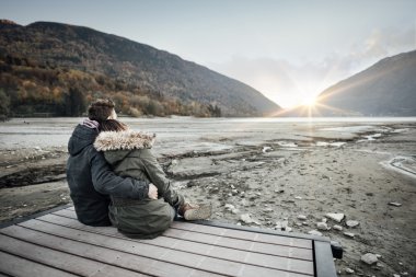 Sevgi dolu çift bir iskelede oturup
