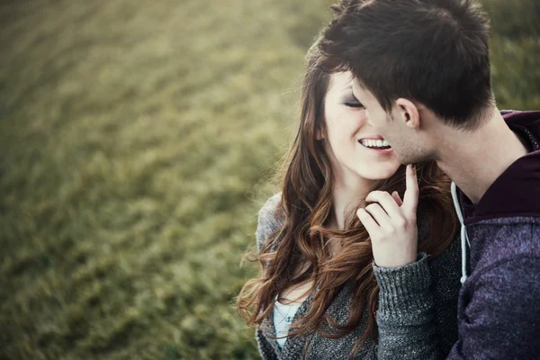 Young loving couple sitting on the grass — Stock Photo, Image