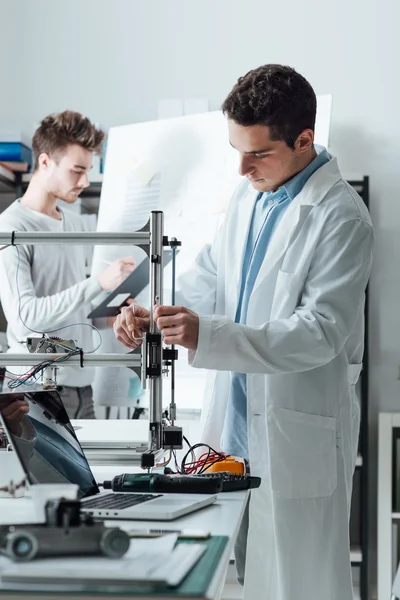 Ingenieros en el laboratorio usando una impresora 3D — Foto de Stock