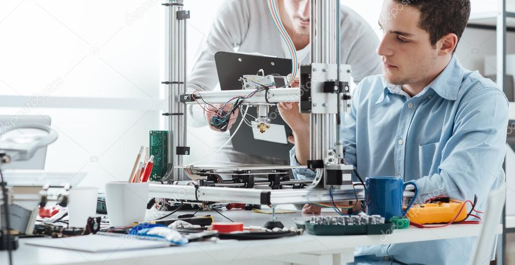 Engineering students using a 3D printer