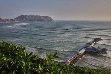 Miraflores 'de sıcak güneşli bir öğleden sonra, Pasifik meltemi ve El Morro Solar' ın yükselişi. Doğa, okyanus ve şehir Limas dramatik kıyı şeridi boyunca mükemmel bir uyum içinde buluşur..