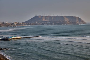 Miraflores 'de sıcak güneşli bir öğleden sonra, Pasifik meltemi ve El Morro Solar' ın yükselişi. Doğa, okyanus ve şehir Limas dramatik kıyı şeridi boyunca mükemmel bir uyum içinde buluşur..