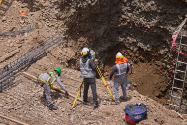 İnşaat işçileri temeli hassasiyet ve güçle güçlendiriyor. Her hareket yeteneği, güvenliği ve kendini adamayı yansıtır. Daha büyük bir şeyin yükselişi için temel oluşturur..