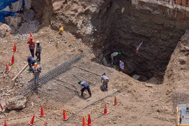 İnşaat işçileri temeli hassasiyet ve güçle güçlendiriyor. Her hareket yeteneği, güvenliği ve kendini adamayı yansıtır. Daha büyük bir şeyin yükselişi için temel oluşturur..