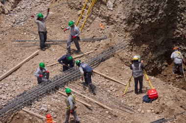 İnşaat işçileri temeli hassasiyet ve güçle güçlendiriyor. Her hareket yeteneği, güvenliği ve kendini adamayı yansıtır. Daha büyük bir şeyin yükselişi için temel oluşturur..