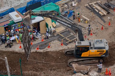 Sarı bir kazıcı, gücünü ve hassasiyetini kullanarak yüksek bir yapının gelecekteki temelini kazıyor. Gücün, ilerlemenin ve her büyük yapının arkasındaki enerjinin sembolü..