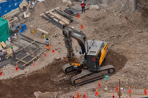 Sarı bir kazıcı, gücünü ve hassasiyetini kullanarak yüksek bir yapının gelecekteki temelini kazıyor. Gücün, ilerlemenin ve her büyük yapının arkasındaki enerjinin sembolü..