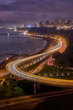 Gece görüşü Miraflores 'in ışık yolları, kıyı yolu ve Pasifik' e yansıyan şehir ışıkları..