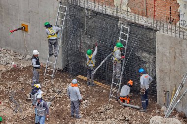 İnşaat işçileri temeli hassasiyet ve güçle güçlendiriyor. Her hareket yeteneği, güvenliği ve kendini adamayı yansıtır. Daha büyük bir şeyin yükselişi için temel oluşturur..