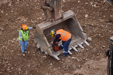 İnşaat işçileri temeli hassasiyet ve güçle güçlendiriyor. Her hareket yeteneği, güvenliği ve kendini adamayı yansıtır. Daha büyük bir şeyin yükselişi için temel oluşturur..