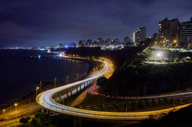 Gece görüşü Miraflores 'in ışık yolları, kıyı yolu ve Pasifik' e yansıyan şehir ışıkları..