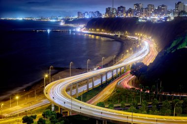 Gece görüşü Miraflores 'in ışık yolları, kıyı yolu ve Pasifik' e yansıyan şehir ışıkları..