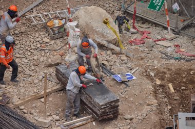 İnşaat işçileri temeli hassasiyet ve güçle güçlendiriyor. Her hareket yeteneği, güvenliği ve kendini adamayı yansıtır. Daha büyük bir şeyin yükselişi için temel oluşturur..