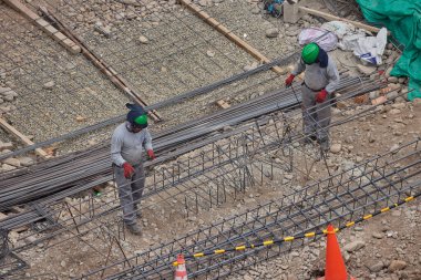 İnşaat işçileri temeli hassasiyet ve güçle güçlendiriyor. Her hareket yeteneği, güvenliği ve kendini adamayı yansıtır. Daha büyük bir şeyin yükselişi için temel oluşturur..