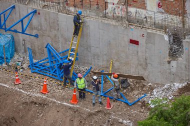 İnşaat işçileri temeli hassasiyet ve güçle güçlendiriyor. Her hareket yeteneği, güvenliği ve kendini adamayı yansıtır. Daha büyük bir şeyin yükselişi için temel oluşturur..