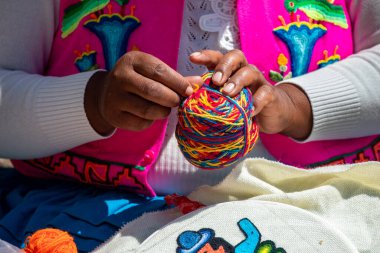 Uros 'un becerikli elleri, geleneksel And desenlerini incelikle işliyor. Her dikiş, kültürel bilgi ve sanatsal ifadenin nesillerini yansıtıyor. Puno Peru