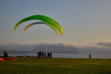 Paragliderler Miraflores 'de kalkışa hazırlanıyorlar. Pasifik' in aşağısına uzanan renkli tepe örtüleri uçurumların üzerinde yükseliyor. Adrenalin, rüzgar ve Limas kıyı ufkunun simgesel bir buluşması..