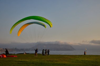 Paragliderler Miraflores 'de kalkışa hazırlanıyorlar. Pasifik' in aşağısına uzanan renkli tepe örtüleri uçurumların üzerinde yükseliyor. Adrenalin, rüzgar ve Limas kıyı ufkunun simgesel bir buluşması..