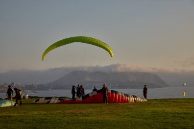 Paragliderler Miraflores 'de kalkışa hazırlanıyorlar. Pasifik' in aşağısına uzanan renkli tepe örtüleri uçurumların üzerinde yükseliyor. Adrenalin, rüzgar ve Limas kıyı ufkunun simgesel bir buluşması..