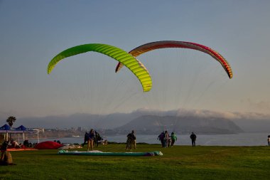 Paragliderler Miraflores 'de kalkışa hazırlanıyorlar. Pasifik' in aşağısına uzanan renkli tepe örtüleri uçurumların üzerinde yükseliyor. Adrenalin, rüzgar ve Limas kıyı ufkunun simgesel bir buluşması..