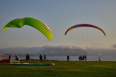Paragliderler Miraflores 'de kalkışa hazırlanıyorlar. Pasifik' in aşağısına uzanan renkli tepe örtüleri uçurumların üzerinde yükseliyor. Adrenalin, rüzgar ve Limas kıyı ufkunun simgesel bir buluşması..