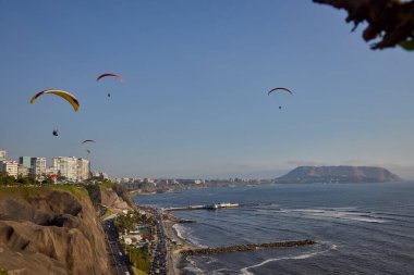 Pasifik aşağıdaki uçurumların üzerinde süzülen paragliderler adrenalini, özgürlüğü ve Limas ikonik kıyı manzarasını unutulamaz bir uçuşla harmanlıyorlar..