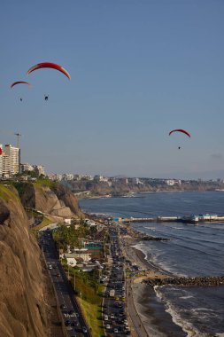 Pasifik aşağıdaki uçurumların üzerinde süzülen paragliderler adrenalini, özgürlüğü ve Limas ikonik kıyı manzarasını unutulamaz bir uçuşla harmanlıyorlar..