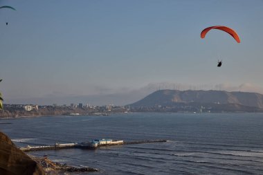 Pasifik aşağıdaki uçurumların üzerinde süzülen paragliderler adrenalini, özgürlüğü ve Limas ikonik kıyı manzarasını unutulamaz bir uçuşla harmanlıyorlar..