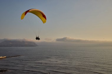 Pasifik aşağıdaki uçurumların üzerinde süzülen paragliderler adrenalini, özgürlüğü ve Limas ikonik kıyı manzarasını unutulamaz bir uçuşla harmanlıyorlar..