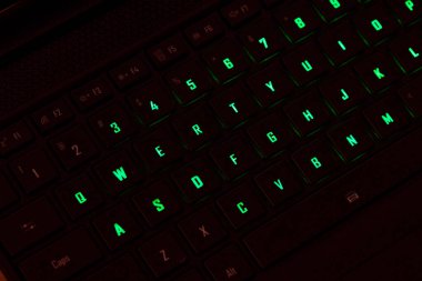 Renkli bir RGB mekanik oyun klavyesinin yakın çekimi canlı renklerle aydınlatılmış. Oyun ayarları için tasarlanmış modern bilgisayar aksesuarı, kişiselleştirilebilir arka ışıklandırma ve şık tasarım.