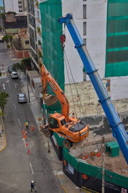Bir kazıcı havada asılı kalmış, yüksek katlı bir bina projesi için kentsel inşaatın arkasındaki ham gücü, hassasiyeti ve riski yakalıyor..