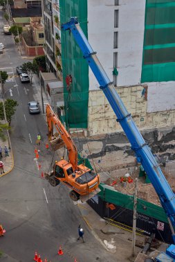 Bir kazıcı havada asılı kalmış, yüksek katlı bir bina projesi için kentsel inşaatın arkasındaki ham gücü, hassasiyeti ve riski yakalıyor..