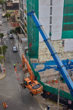 Bir kazıcı havada asılı kalmış, yüksek katlı bir bina projesi için kentsel inşaatın arkasındaki ham gücü, hassasiyeti ve riski yakalıyor..