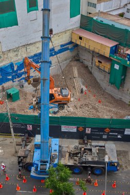 Bir kazıcı havada asılı kalmış, yüksek katlı bir bina projesi için kentsel inşaatın arkasındaki ham gücü, hassasiyeti ve riski yakalıyor..