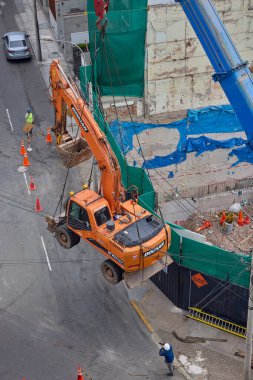 Bir kazıcı havada asılı kalmış, yüksek katlı bir bina projesi için kentsel inşaatın arkasındaki ham gücü, hassasiyeti ve riski yakalıyor..