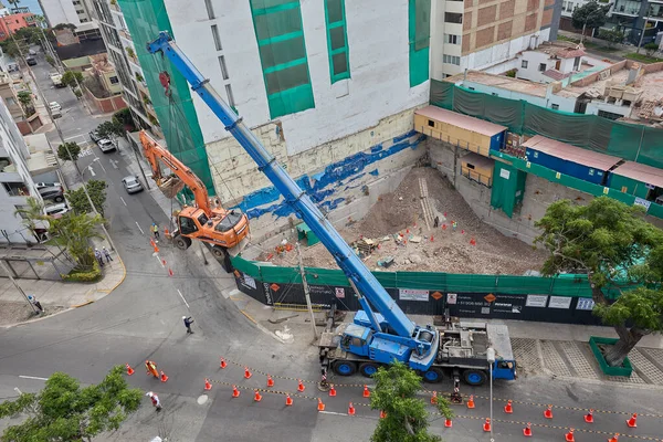 Bir kazıcı havada asılı kalmış, yüksek katlı bir bina projesi için kentsel inşaat alanının arkasındaki ham güç, hassasiyet ve riski yakalıyor..