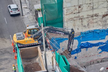 Büyük bir inşaat sahasında faaliyet gösteren üç kazıcı, yeni bir emlak gelişimi için ağır makineler kazma temelleri, altyapı büyümesi, mühendislik ilerlemesi ve modern şehir genişlemesi