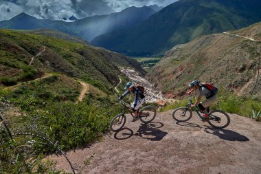 Peru 'nun kutsal vadisi Cusco' da sınırlarını Andean manzaraları ve antik tarım arazileriyle çevreleyen dağ bisikletçileri zorluyor. Bu dinamik açık hava sahnesi macera seyahatini, aktif yaşam tarzını yakalar.,