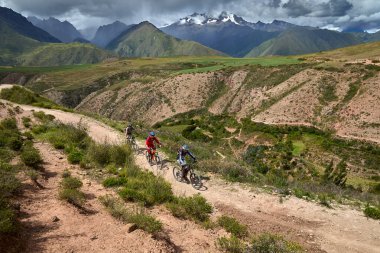 Peru 'nun kutsal vadisi Cusco' da sınırlarını Andean manzaraları ve antik tarım arazileriyle çevreleyen dağ bisikletçileri zorluyor. Bu dinamik açık hava sahnesi macera seyahatini, aktif yaşam tarzını yakalar.,