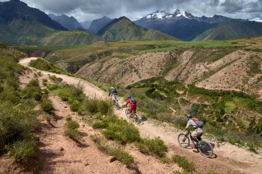 Peru 'nun kutsal vadisi Cusco' da sınırlarını Andean manzaraları ve antik tarım arazileriyle çevreleyen dağ bisikletçileri zorluyor. Bu dinamik açık hava sahnesi macera seyahatini, aktif yaşam tarzını yakalar.,