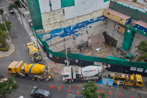 Ağır vinç kazıcıyı şehir ortamında derin bir inşaat sahasına kaldırıyor, altyapı geliştirme, gayrimenkul büyümesi ve modern şehir genişlemesi sergiliyor..