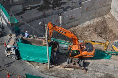 Miraflores 'te büyük bir inşaat sahasında faaliyet gösteren kazıcılar, büyüyen bir şehir ortamında güvenli çalışma uygulamaları, modern inşaat standartları ve kentsel emlak gelişimini gösteriyorlar..