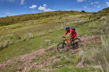 Peru, Cusco 'da antik dağlık patikalar boyunca seyahat eden bir grup dağ bisikletçisi, otantik yerel kültür, tarihi manzaralar ve uzak bir And ortamında aktif bir yaşam tarzı ve keşif ruhunu yansıtan açık hava maceraları yaşıyorlar..
