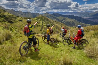 Peru, Cusco 'da antik dağlık patikalar boyunca seyahat eden bir grup dağ bisikletçisi, otantik yerel kültür, tarihi manzaralar ve uzak bir And ortamında aktif bir yaşam tarzı ve keşif ruhunu yansıtan açık hava maceraları yaşıyorlar..